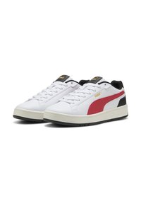 Des baskets de sport blanches avec une tige en cuir texturé, des accents rouges et noirs, et une semelle en caoutchouc. Elles présentent un système de laçage et des détails de logo.