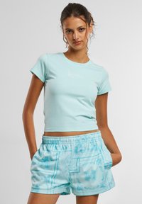 Lyseblå kortermet t-skjorte med enkel hvit logo. Kombinert med mønstrede blå shorts, elastisk midje og lommer.