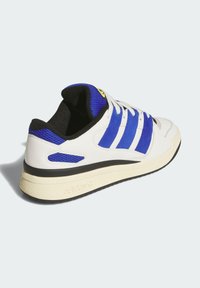 White sneaker with blue mesh accents, black inner lining, flat laces, and a chunky cream outsole. Features three blue stripes and logo detail.