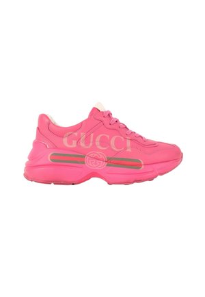 Jasnoróżowy sneaker Gucci z grubą podeszwą, sznurowaniem i logo po boku na białym tle.
