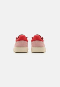 Røde og rosa semskede sneakers med en hvit læroverdel, featuring en beige gummisåle og polstret ankelkrage for komfort.