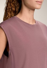 Top fără mâneci, culoare mov pal, cu gât rotund, din amestec de bumbac texturat, având decupaje largi la brațe și croială lejeră pentru confort.