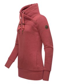 Punainen korkea kauluksellinen collegepaita, jossa on teksturoitu pinta. Siinä on nyörit, sivutasku ja pyöreä logo hihassa.