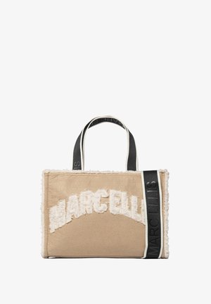 Borsa a mano in tessuto beige con dettagli in peluche bianco e testo "MARCELLIS" ricamato. Presenta manici e rifiniture nere a contrasto.