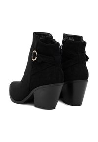 Czarne zamszowe botki za kostkę z okrągłym noskiem, ozdobnym złotym pierścieniem oraz grubym obcasem. Posiadają zamek błyskawiczny i teksturowany obcas.