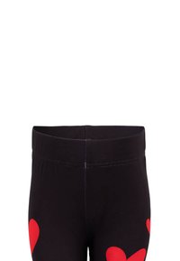 Czarne legginsy z dużymi czerwonymi wzorami serc, wykonane z elastycznego materiału. Pas jest elastyczny, co zapewnia wygodę i łatwość noszenia.