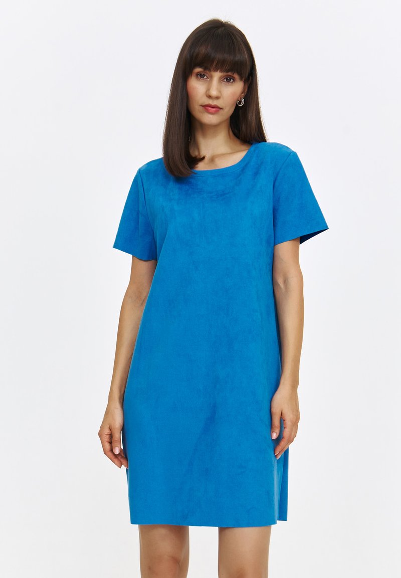 Niebieska sukienka z krótkim rękawem wykonana z miękkiego, zamszowego materiału. Ma okrągły dekolt i luźny, prosty krój.