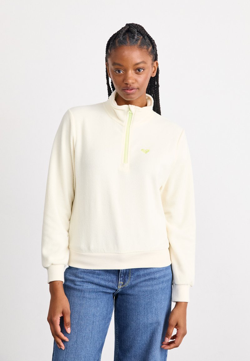 Cream fleece pullover with a high collar and half zipper in neon green. Features ribbed cuffs and waistband. Small logo on chest.