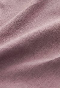 Tekstilstof i lys mauve, med en glat, let struktureret overflade, der har subtile folder og et naturligt, luftigt udseende.
