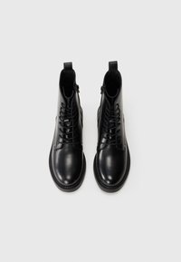 Black leather ankle boots with a smooth texture, featuring a front lace-up design and side zipper for easy wear. Rounded toe and stitched detailing.