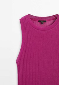 Haut sans manches en maille côtelée de couleur magenta vif avec un col rond et une étiquette de vêtement visible à l'intérieur du col.
