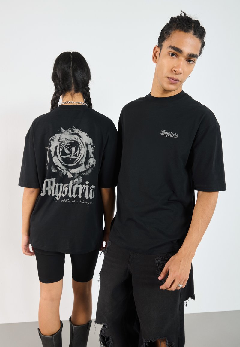 Black cotton t-shirts, one featuring a rose graphic and text on the back. The other shirt has a small logo on the front. Both have a relaxed fit.
