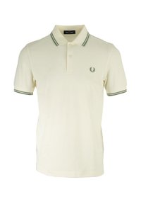 Polo in cotone crema con colletto e polsini a righe verdi. Presenta un piccolo logo ricamato sul lato sinistro del petto. Vestibilità classica.