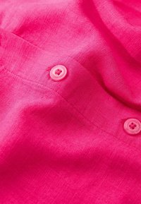 Fuchsia pink stof med en linned-textur, der har to lyserøde knapper. Stoffet har en subtil glans og blød fald.