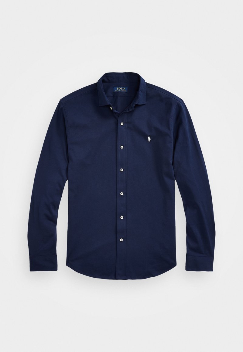 Pitkähihainen tummansininen napillinen paita, valmistettu puuvillasta, jossa klassinen kaulus, valkoiset napit ja pieni kirjailtu logo rinnassa.