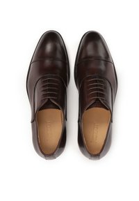 Rjavi usnjeni elegantni čevlji z okroglim prstom, subtilnimi šivi in gladko teksturo. Imajo vezalke in oblazinjen vložek.