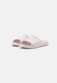Rosa sky sandaler med åpen tå-design, teksturert overflate og perforeringer på overdelen for pusteevne; laget av fleksibelt gummimateriale.