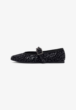 Chaussure plate noire de type Mary Jane avec un imprimé léopard gris foncé et une sangle à boucle métallique sur le dessus, présentée de profil sur fond blanc.
