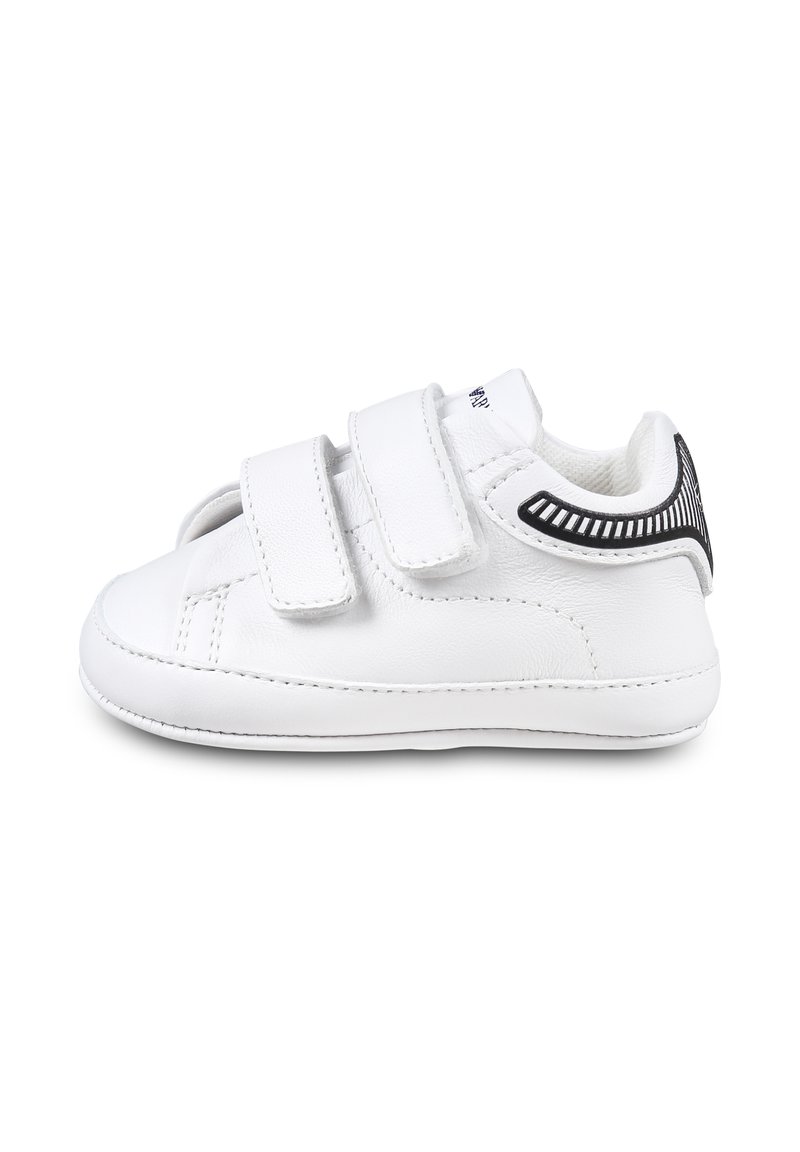 Witte leren sneaker met twee klittenbandsluitingen, ronde neus, textuur zwart accent op de hak en gestikte details langs de zool.