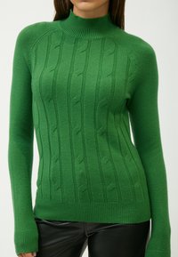 Grüner Strickpullover mit hohem Kragen, gerippten Bündchen und Saum, ausgestattet mit einem strukturierten Zopfmuster und einer taillierten Passform.