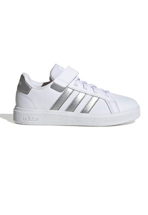 Zapatillas de cuero blancas con suela texturizada, que cuentan con tres rayas plateadas y una correa de Velcro para el cierre. Diseño minimalista y punta redondeada.