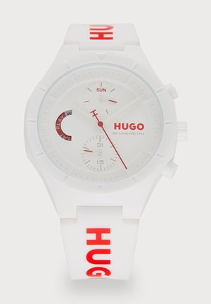 White silicone watch with red accents, featuring a circular face, three sub-dials, and "HUGO" branding on the strap and dial.