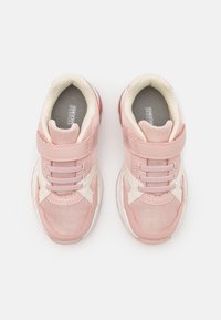 Ett par rosa och vita barnsneakers med övre i mesh och läder, kardborreband och snören, uppifrån med vit bakgrund.