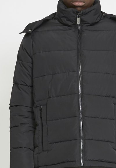 Giacca a vento nera con collo alto, zip davanti e tasche laterali. Presenta un motivo a righe orizzontali e dettagli a scatto sulle spalle.