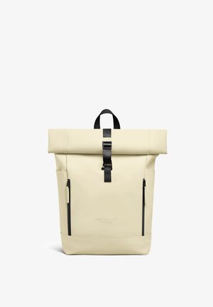 Zaino beige con chiusura a rotolo, cinturino con fibbia nera, due tasche verticali con cerniera e manico per il trasporto, marchiato Gaston Luga Stockholm.