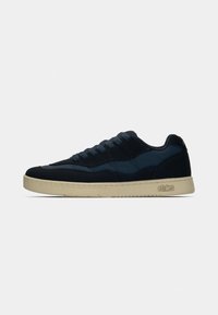 Sneaker blu navy a bassezza con lacci scuri e suola beige, logo "etnies" impresso sul lato esterno della suola.