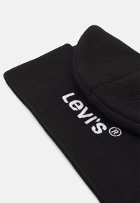 Czarna dzianinowa czapka z mankietem, z białym haftowanym logo "Levi's". Miękka struktura i gładkie wykończenie.