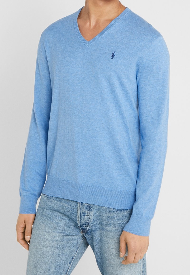 Ljusblå V-ringad pullovertröja i mjukt material, med lång ärm, ribbade mudd och en liten logotyp på vänster bröst.