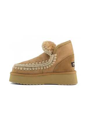 Stivaletti alla caviglia in suede beige con punta rotonda, dettagli decorativi in treccia, un morbido risvolto e una suola spessa beige. Etichetta del marchio sul tallone.