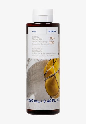 Bouteille de gel douche aux agrumes avec extrait purifiant de sauge, adaptée aux peaux sensibles, 250 mL, avec des citrons en filet sur l'étiquette.