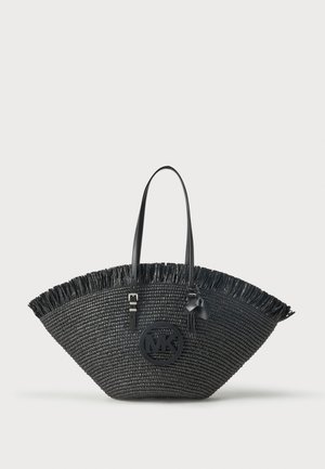 Borsa tote nera a forma di ventaglio intrecciato con bordo superiore frangiato, manici in pelle e un charm rotondo con logo "MK" sul davanti.