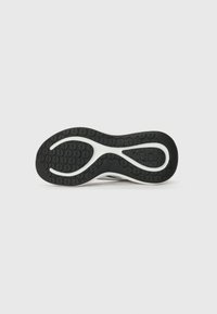 Black rubber outsole with a textured pattern, featuring a white section in an abstract shape. Smooth edge, designed for grip and flexibility.