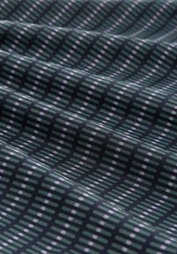Textiel met een donkergroene achtergrond en een geometrisch patroon van dunne witte en groene lijnen, wat zorgt voor een textuureffect.