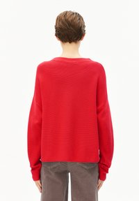 Rode gebreide trui met een geribbeld verband, oversized pasvorm en brede mouwen. De achterkant heeft een ronde halslijn en subtiele stikseldetails.