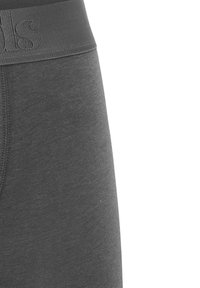 Leggings en coton gris avec une large taille élastique comportant un logo en relief. Texture lisse avec une coupe ajustée.