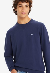 Marineblauwe sweatshirt van katoen, met een ronde hals, geribbelde manchetten en een klein wit Levi's logo op de borst.