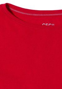 T-shirt en coton rouge avec un col rond côtelé et des détails de couture visibles. Design simple, couleur unie, sans motifs ni graphismes.