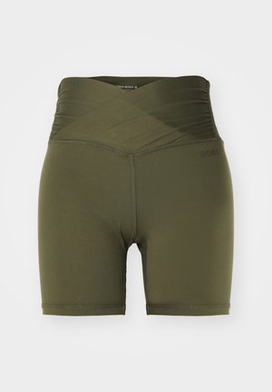 Shorts vert olive avec un design taille haute croisées, fabriqués dans un tissu lisse et extensible, présentant des coutures minimales et un accent de logo.
