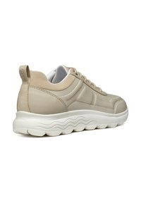 Helle beige Sneaker mit einem Obermaterial aus Mesh und Wildleder. Verfügt über eine massiven weißen Sohle mit wellenförmigem Design und einer Zuglasche an der Ferse. Schnürverschluss.