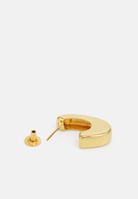 Orecchino a cerchio in oro, forma curva con texture liscia e lucida. Include un retro a perno separato per una vestibilità sicura.