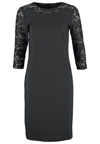 Vestido negro de tela suave, con mangas de encaje tres cuartas y un escote redondo. Silueta simple con un corte a la altura de la rodilla.