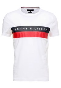 Biała bawełniana koszulka z czarnym poziomym paskiem z czerwonymi akcentami i napisem "TOMMY HILFIGER" wydrukowanym na białym tle. Krótkie rękawy.