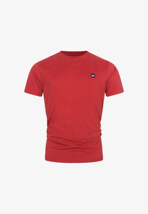 Camiseta de algodón roja con mangas cortas, escote redondo y un pequeño logo negro en el pecho izquierdo. Textura suave, corte clásico.