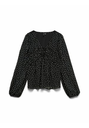 Blouse noire à manches longues avec pois blancs, col en V, détail froncé sur la poitrine et poignets élastiques aux manches.