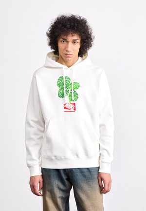 White hoodie with a kangaroo pocket, featuring a green plant graphic and red Nike logo. Ribbed cuffs and hem, soft fabric texture.