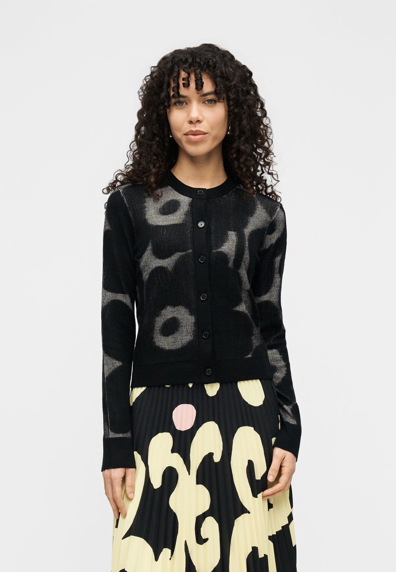 Μαύρη ζακέτα με ανθισμένο μοτίβο σε γκρι, διαθέτει στρογγυλή λαιμόκοψη, εμπρόσθιο κούμπωμα με κουμπιά και υφασμάτινη πλεκτή υφή.